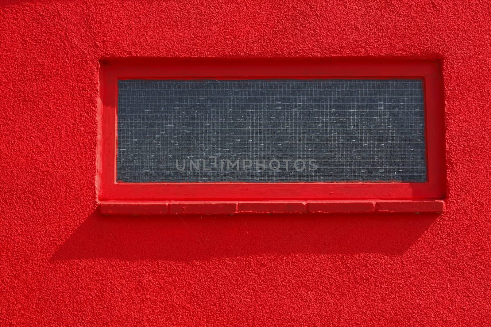 basement windows on a red house wall