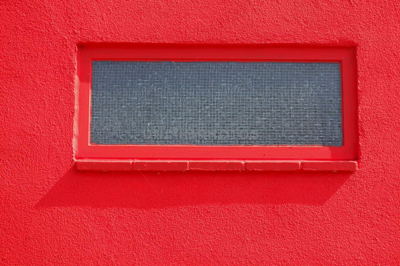 basement windows on a red house wall