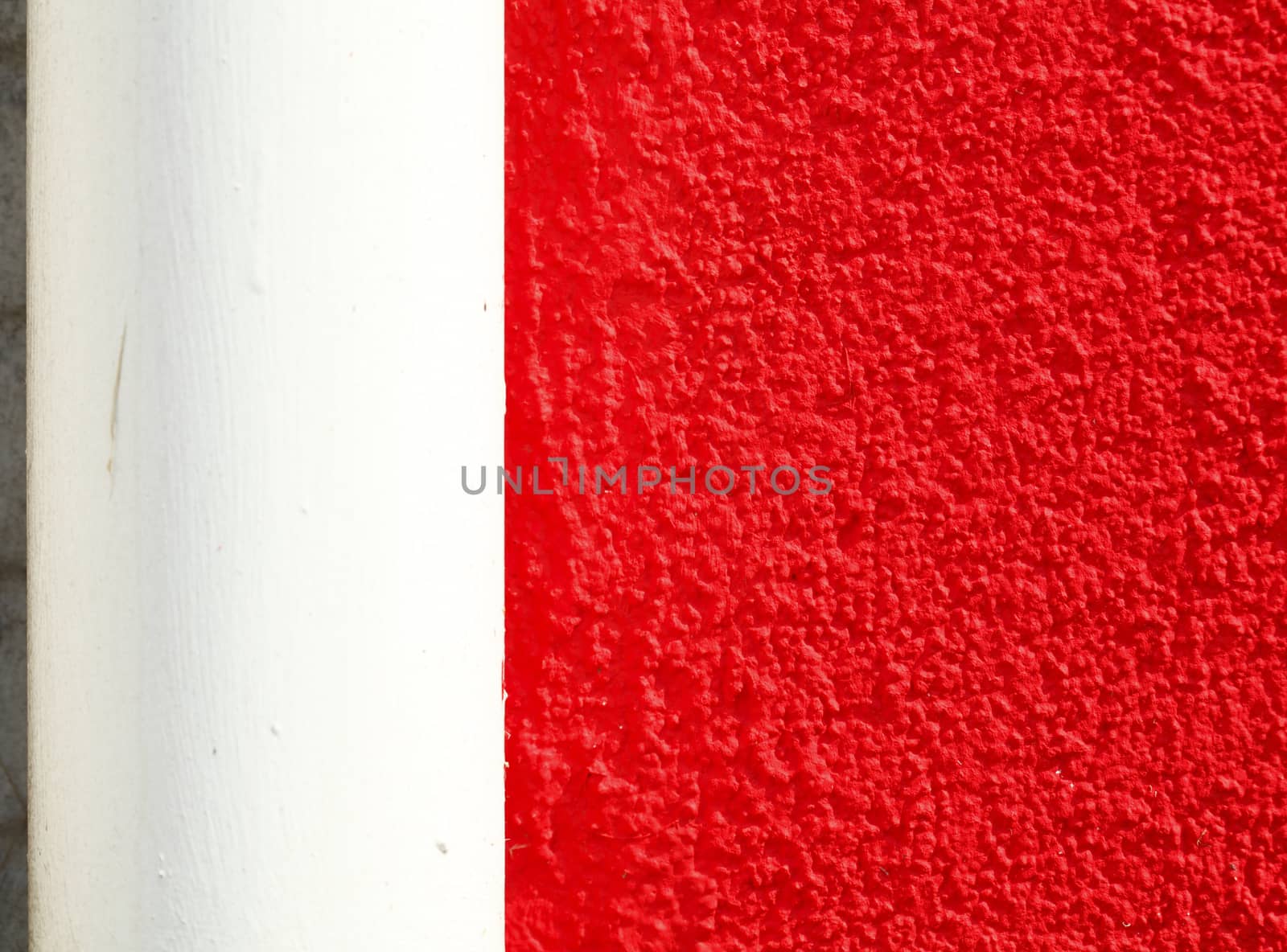  red painted  concrete house wall  with water pipe
