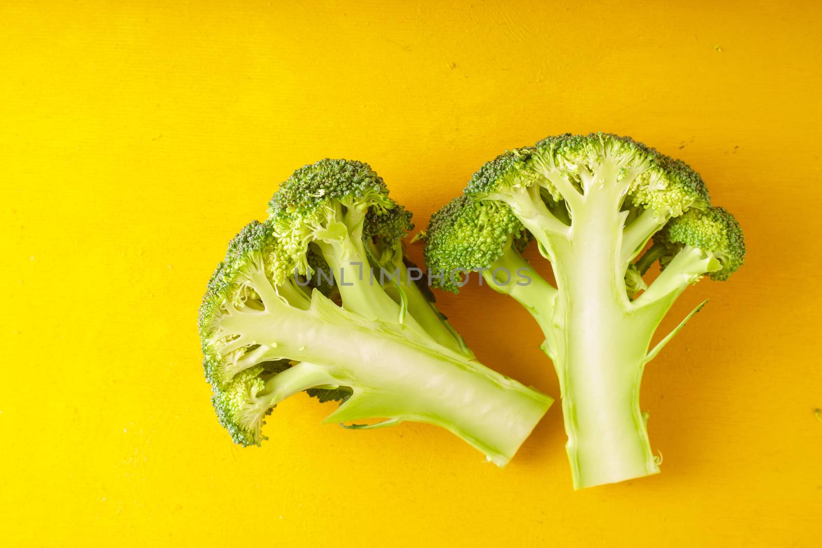 Fresh broccoli on a yellow table horizontal