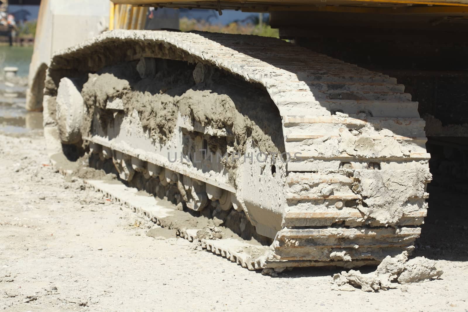Muddy Chain Weels of an Excavator in the Sand