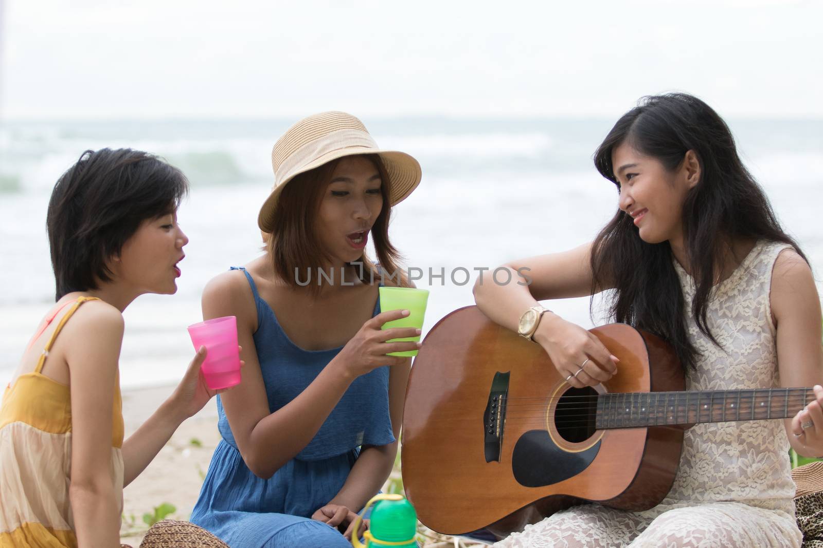 portrait of asian woman and friends group playing guitar and hap by khunaspix