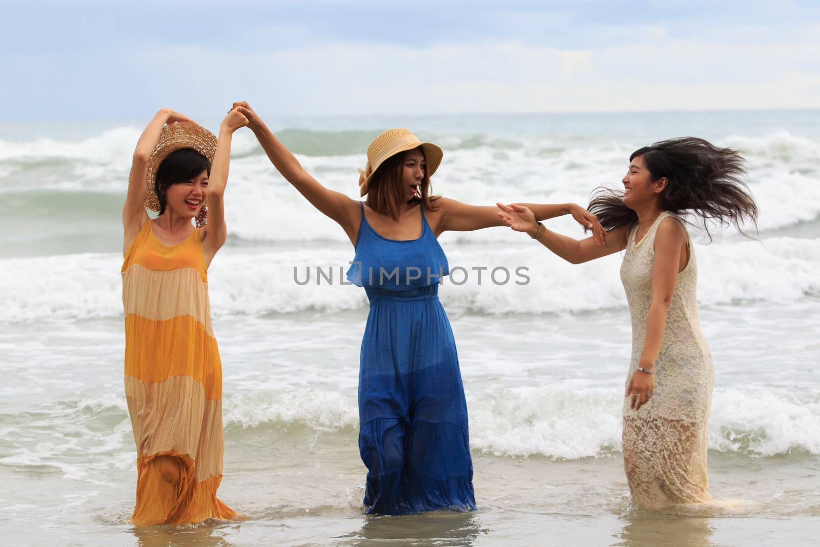 portrait of young asian woman with happiness emotion wearing beautiful dress dancing on sea beach and laughing joyful use for people relaxing vacation on destination