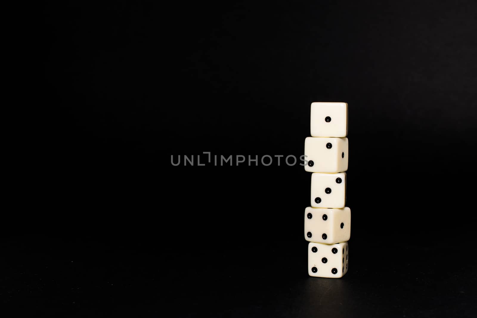 Five dice disposed in vertical position on a black background