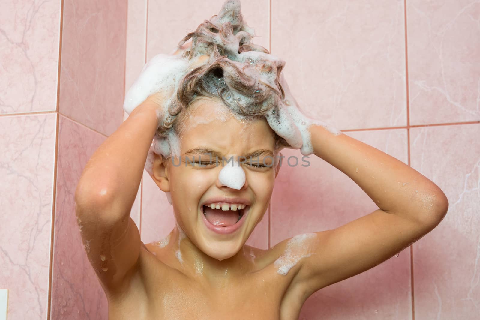 Funny girl washing her hair with shampoo