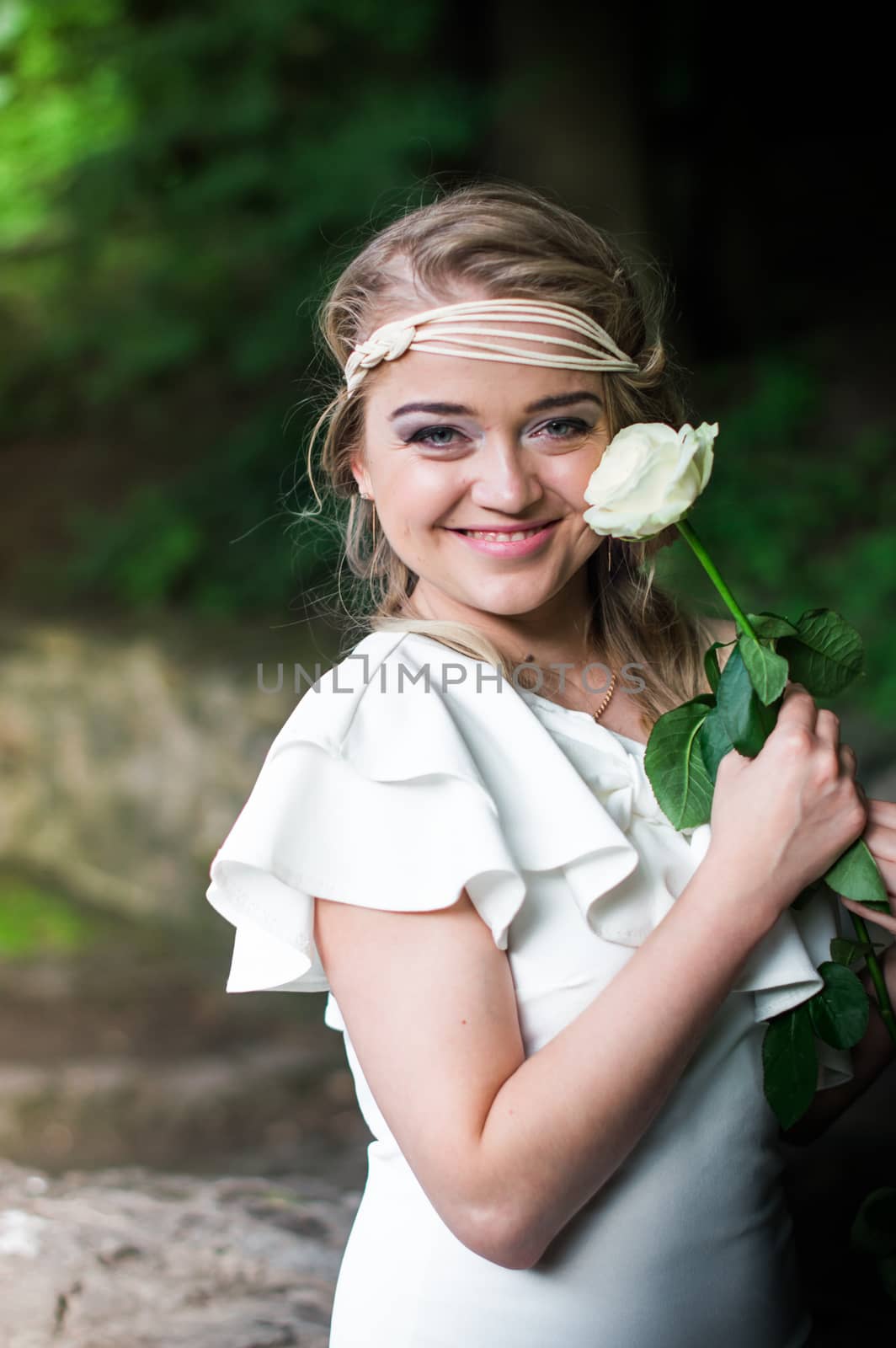 beautiful girl with a white rose in the Park on the grass