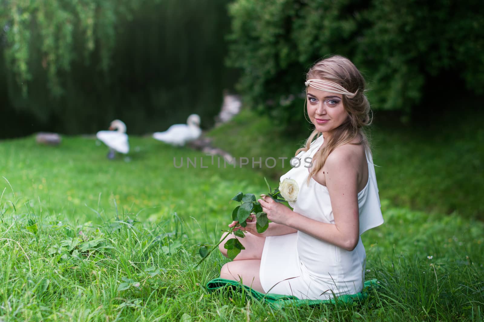 beautiful girl with a white rose in the Park on the grass