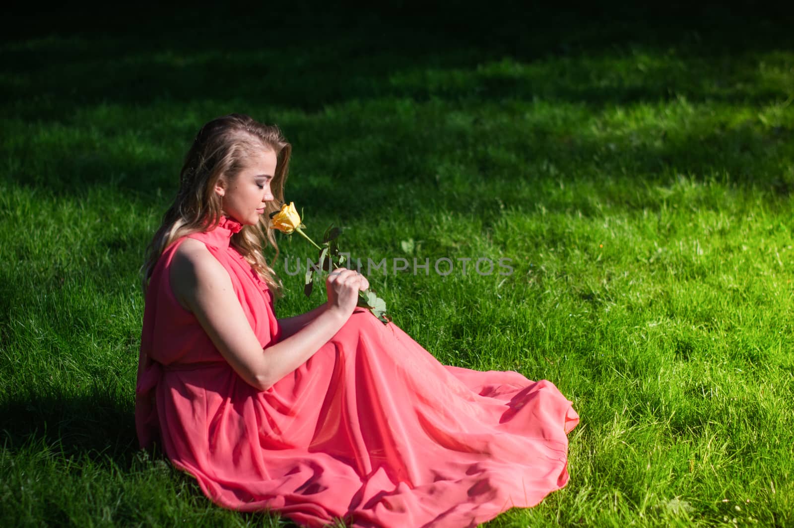 beautiful girl sniffing white rose in the Park