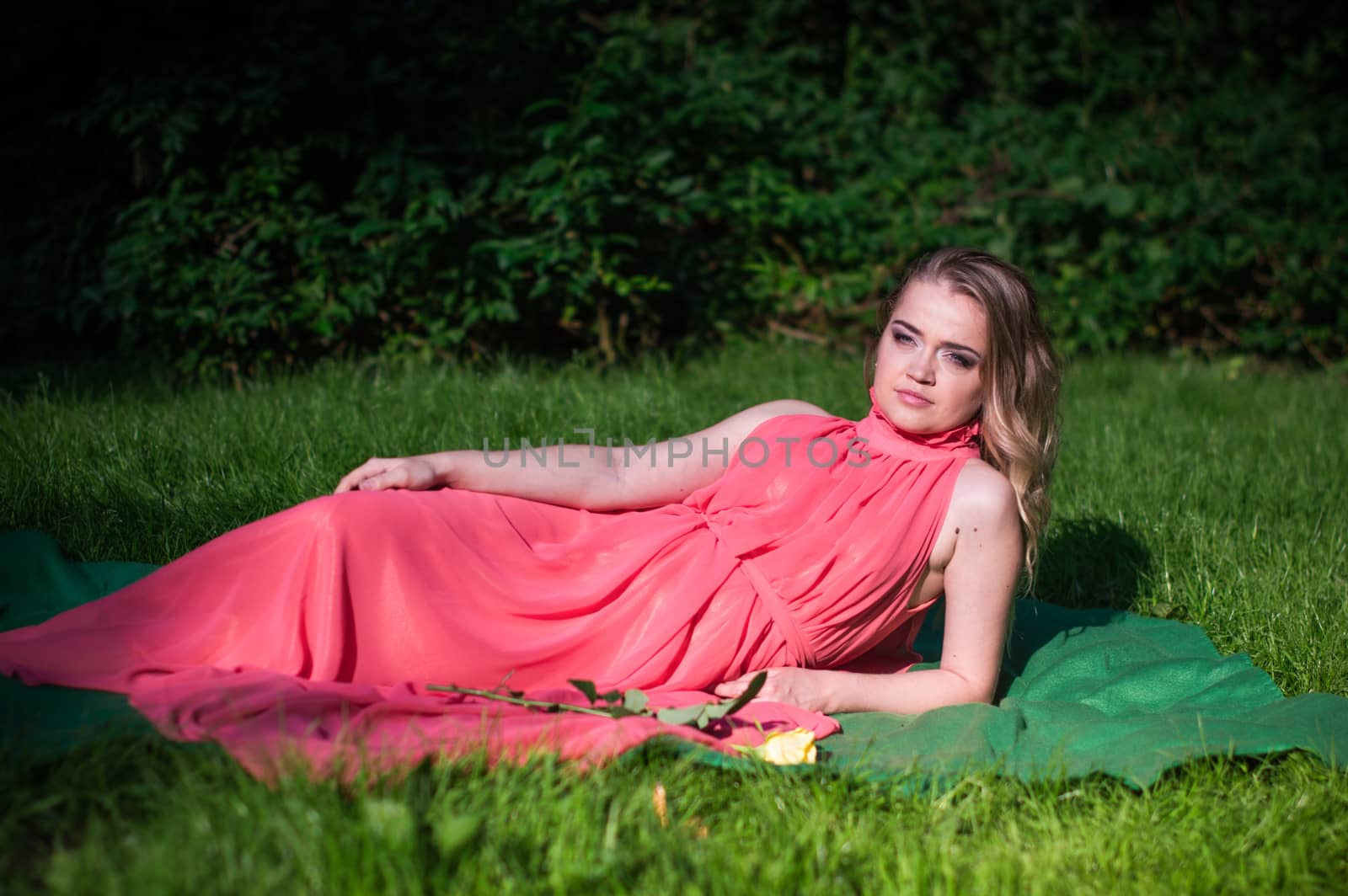 beautiful girl with a white rose in the Park on the grass