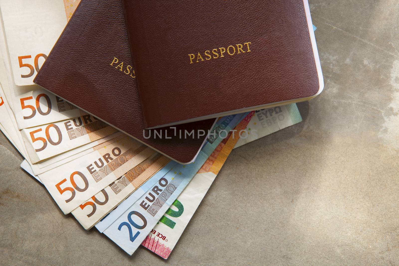 red passport book cover and euro banknote on earth tone backgrou by khunaspix