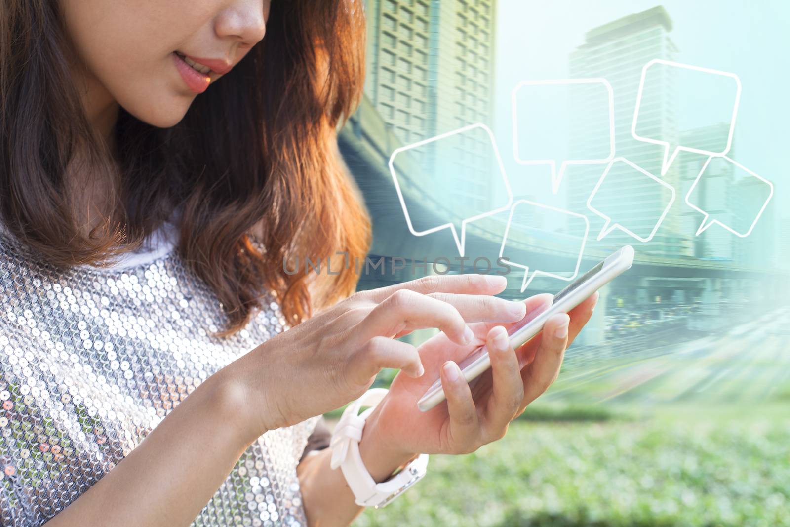 close up younger woman touching on smart phone screen and quotes bubble floating against city building background