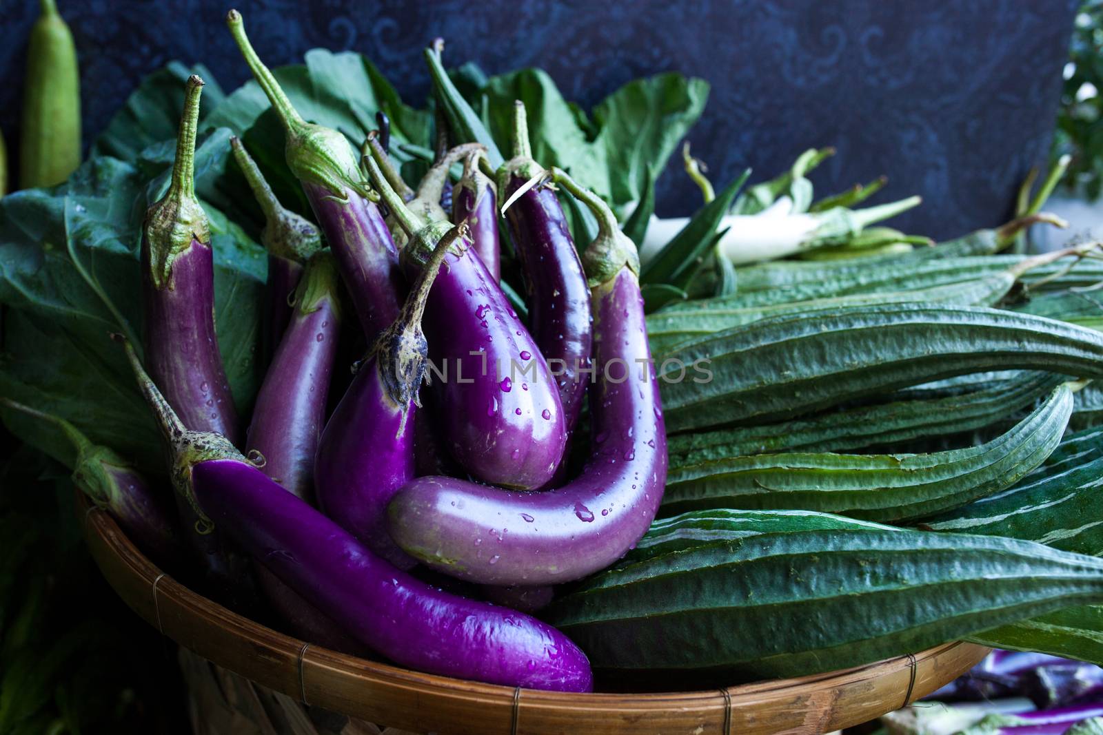 Fresh healthy eggplants on dark background by nopparats