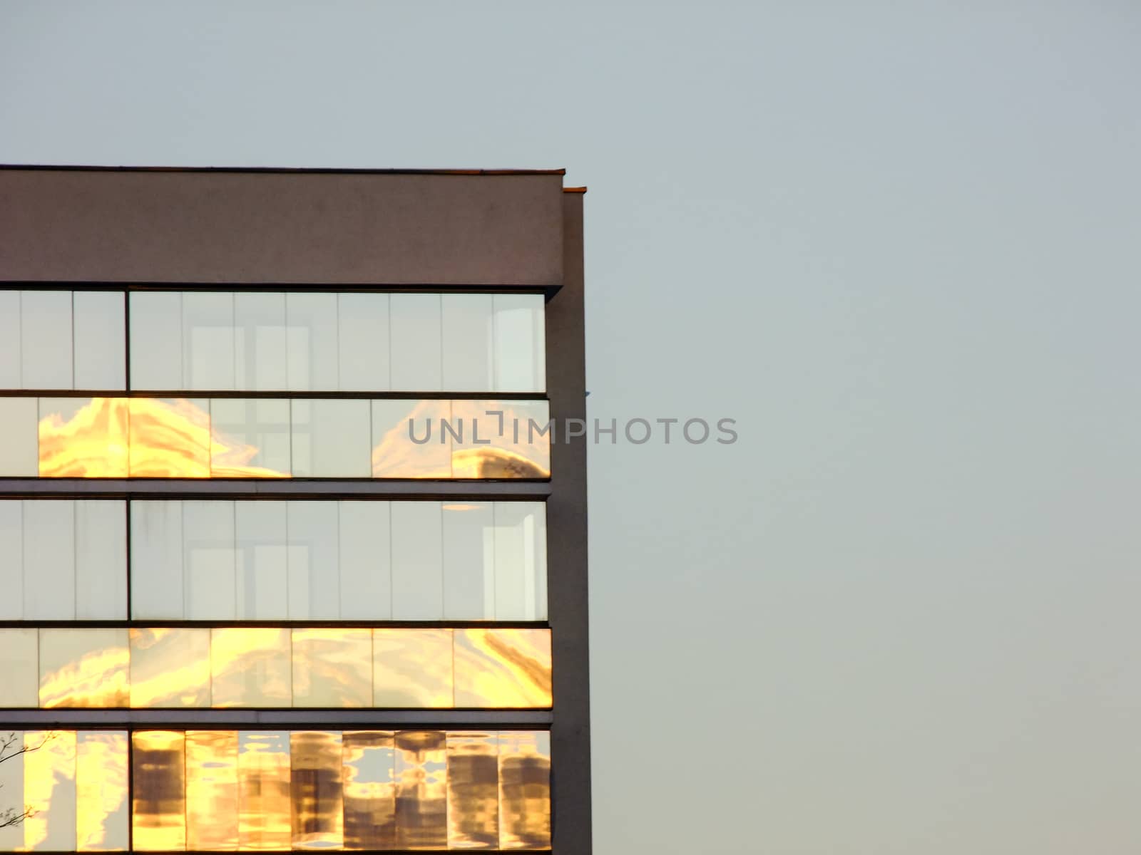 Modern Glass and Concrete Building on the left Side Corner of deep blue Sunset Sky Background