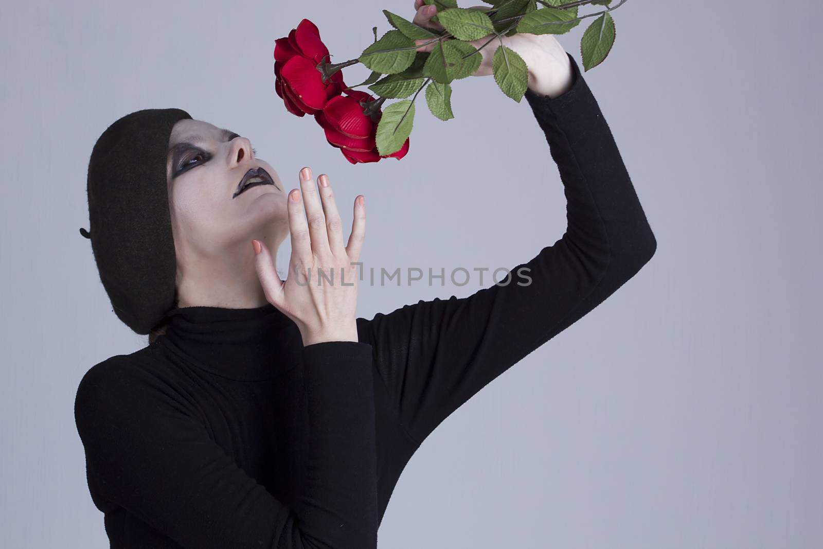 Young woman mime with red roses