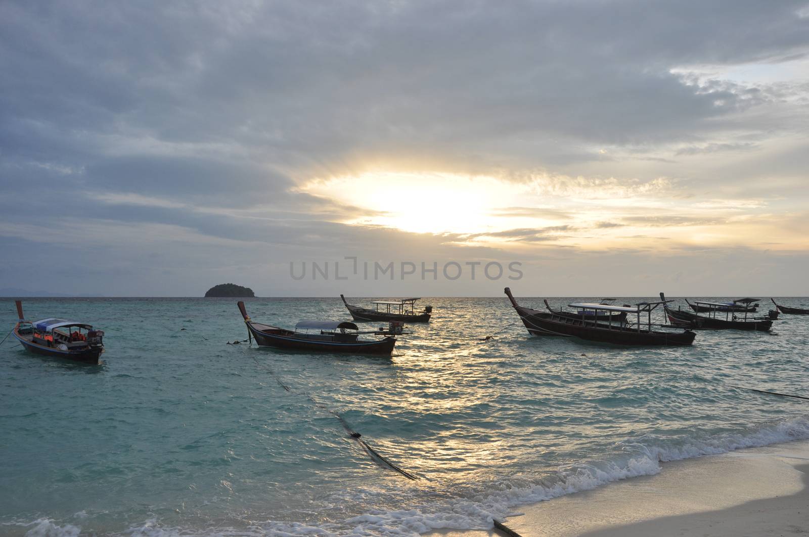Boat in the sea with sunrise and island background