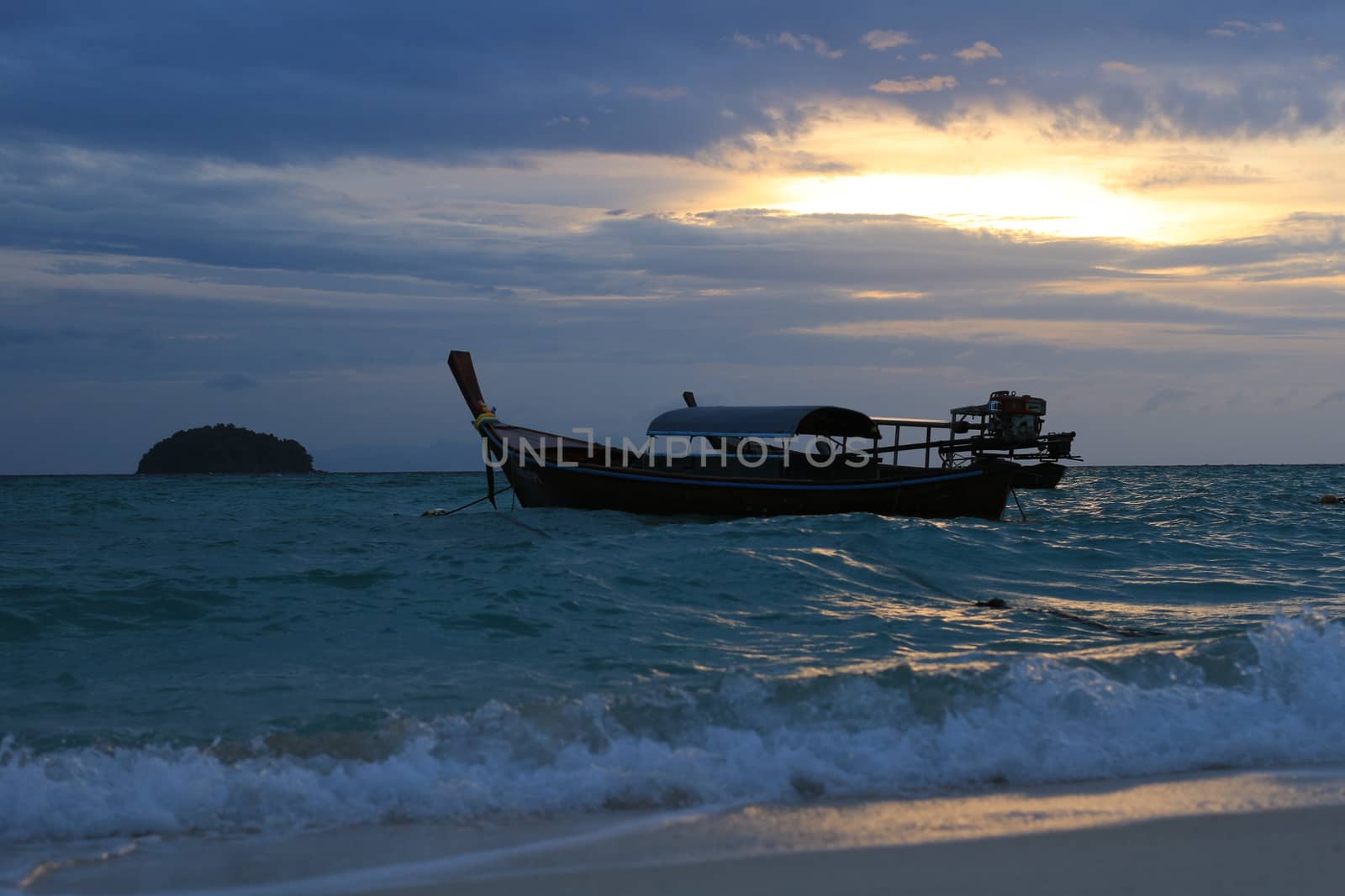 Boat in the sea with sunrise and island background