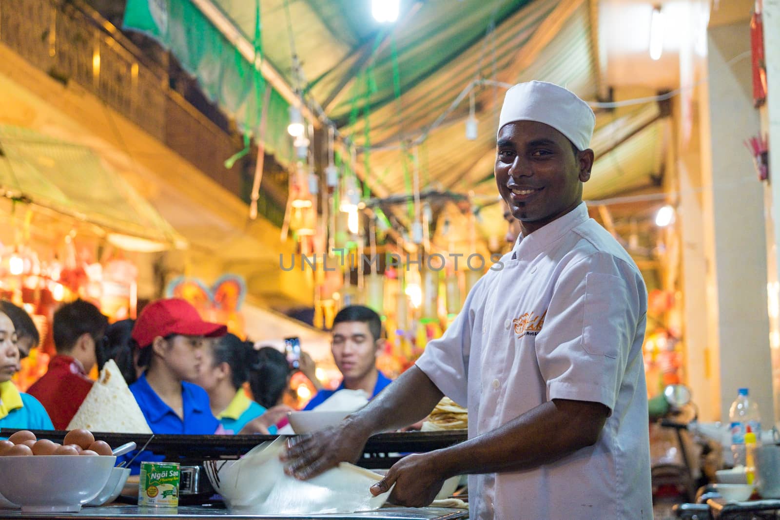 A malaysian chef is baking on street with smile