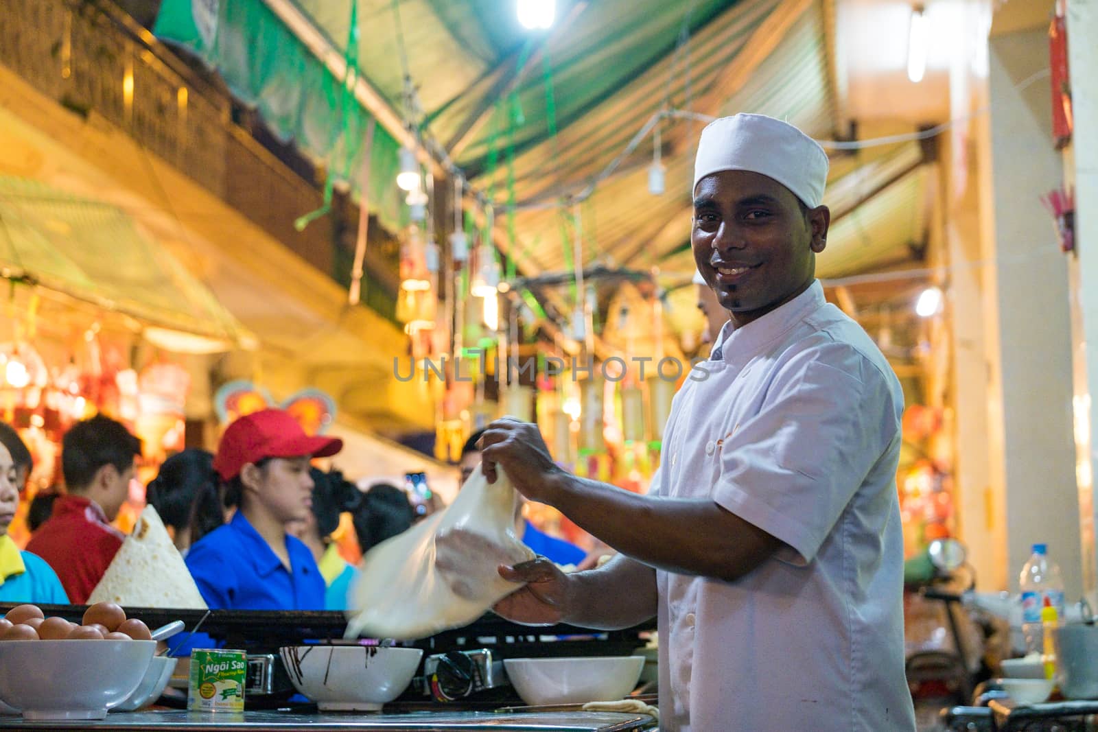 A malaysian chef is baking on street with smile
