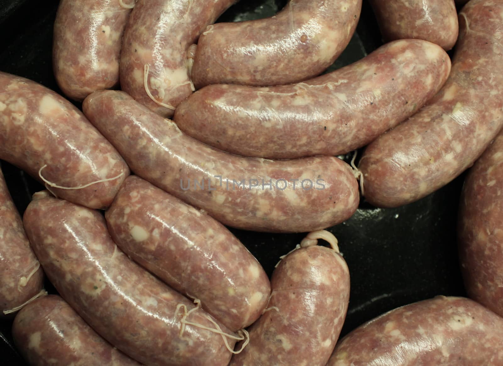 raw meat sausages on black background  above close-up