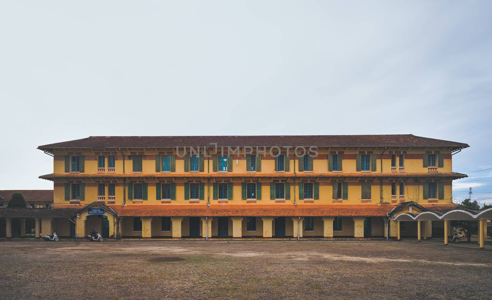 Arched architectural beauty, rustic buildings Pedagogical University in sunny with red roofing tiles impressive pines in Da Lat city, Lam Dong, Vietnam