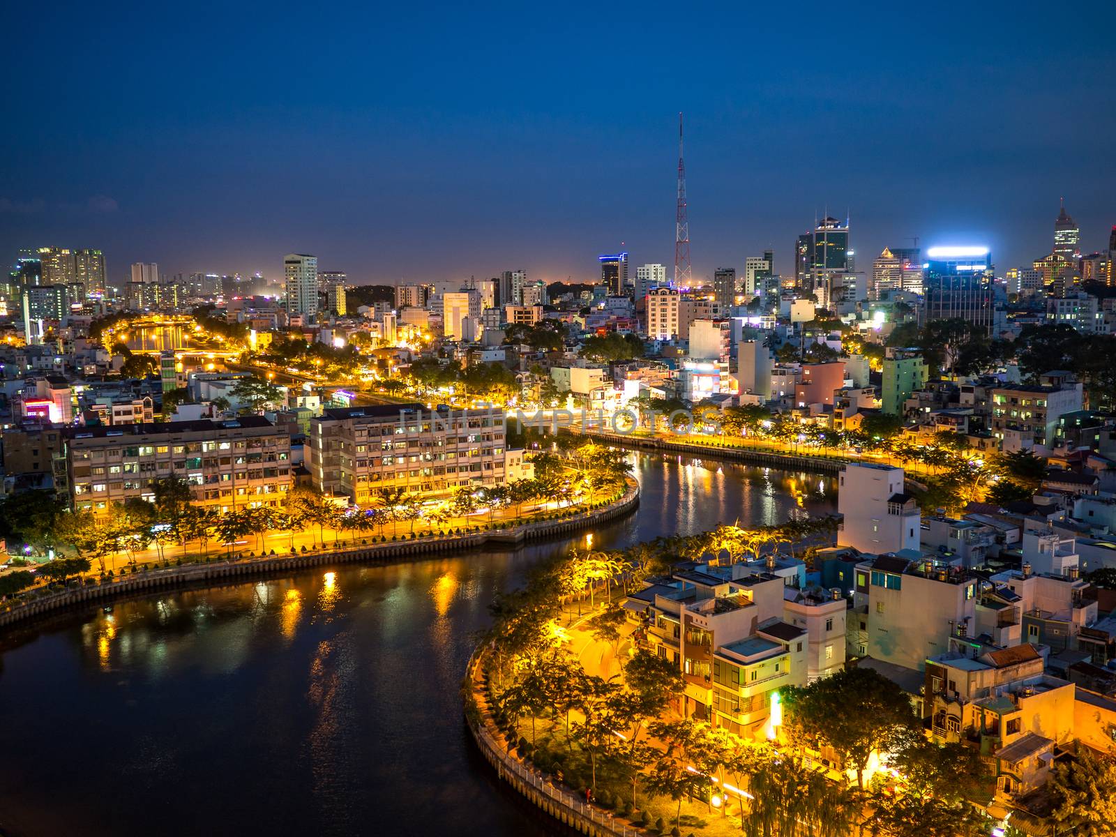 Aerial night city view of houses and Business Center of Ho Chi Minh city on Nhieu Loc canal