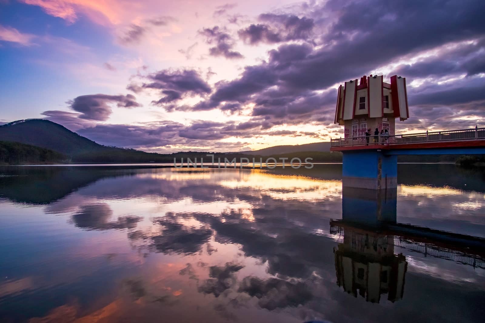 Reflection of pine tree and bridge on lake in sunset. TUYEN LAM lake, LAMDONG, VIETNAM