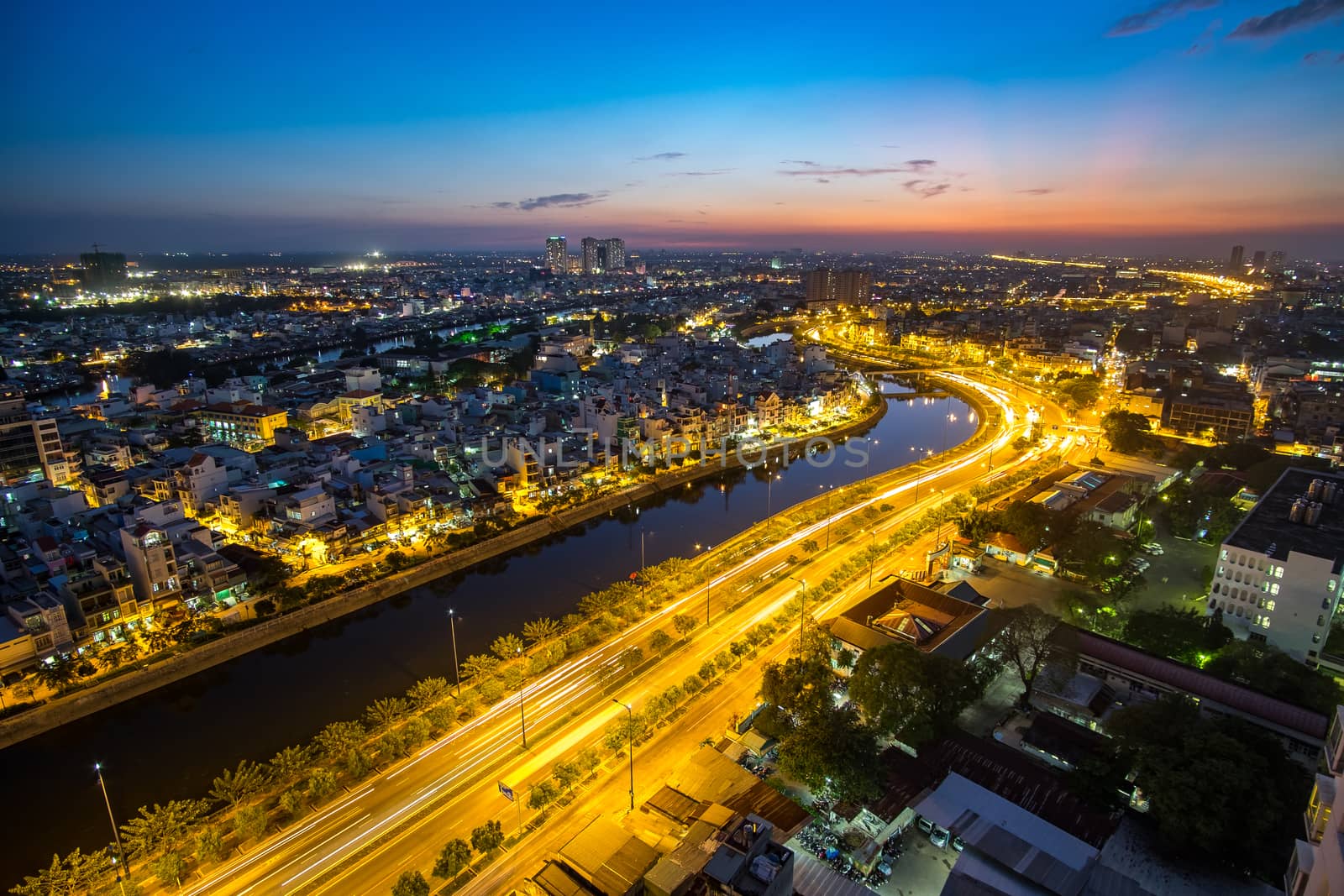 Colourful night city with clouds on Tau Hu canal and the East-West Highway (Vo Van Kiet street) in Ho Chi Minh City (Saigon).View from a roof of building