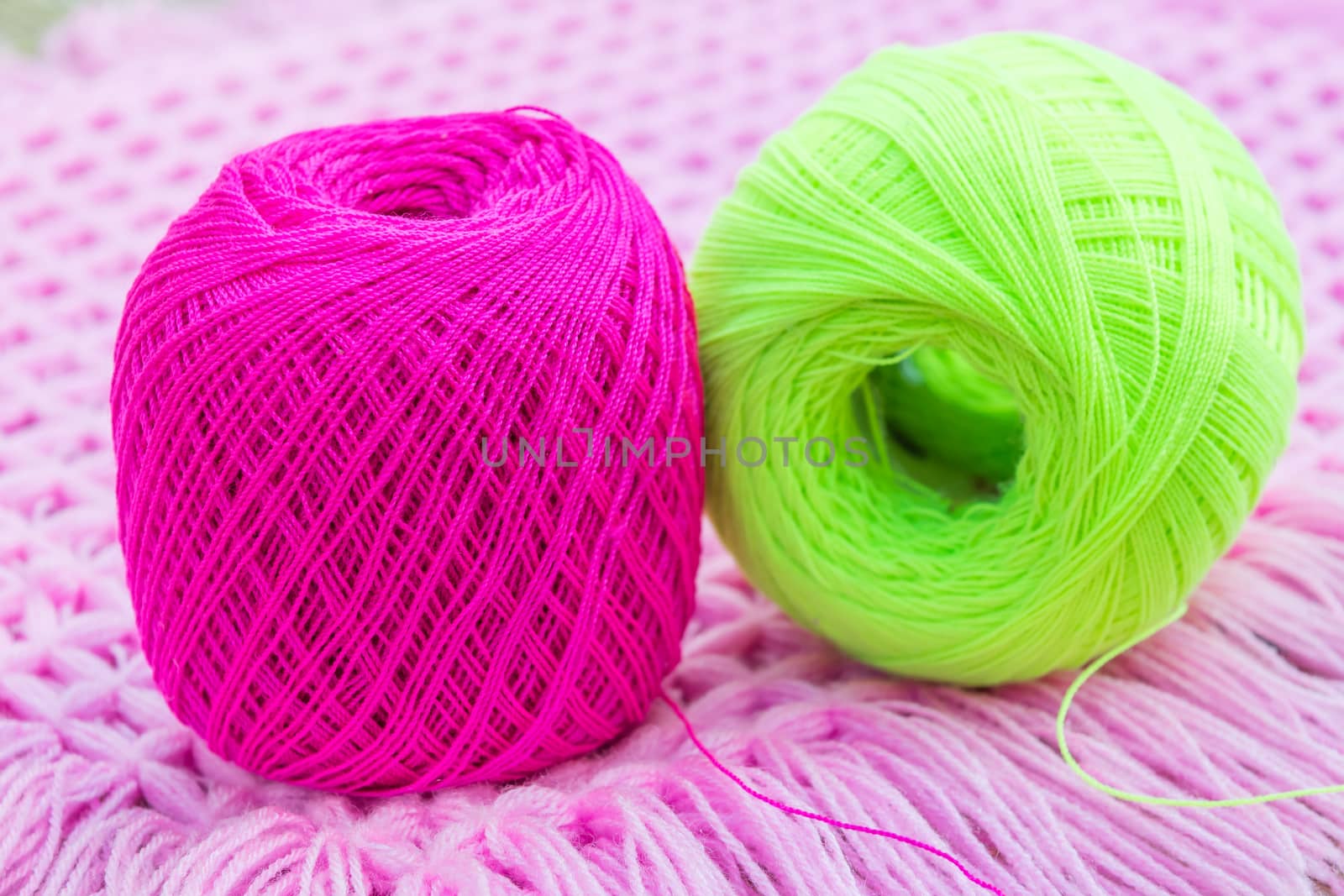 balls of pink and green knitting yarn