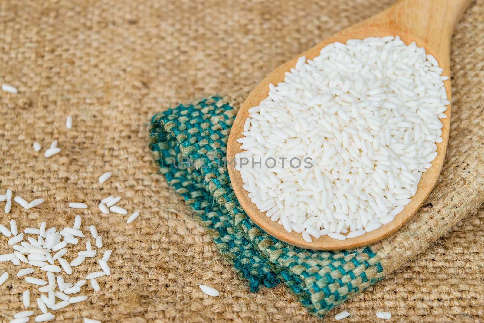 Glutinous rice in wooden spoon with hemp sacks background