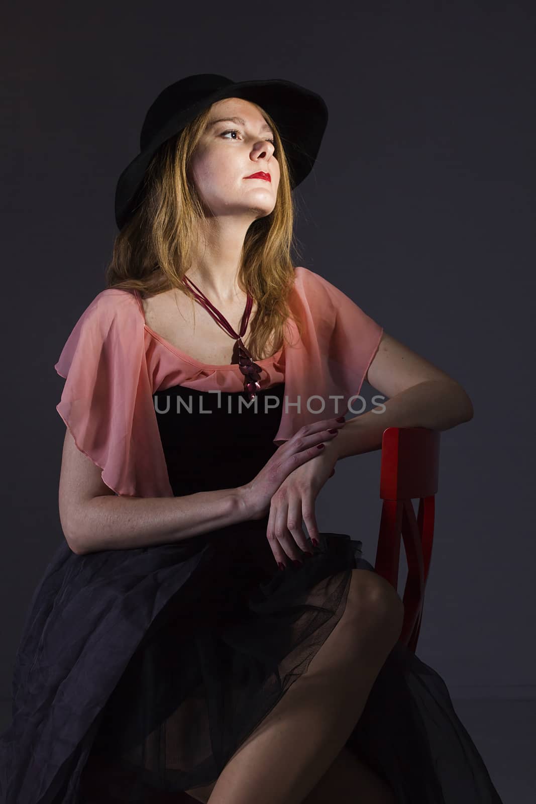 Portrait of a young woman in a hat on a black background