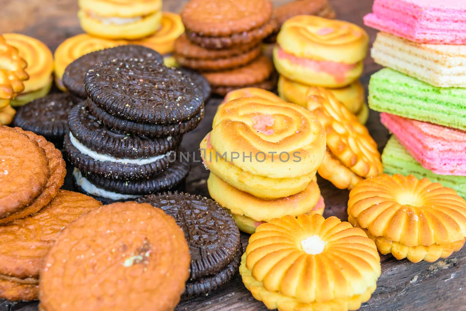 Colorful candy cookies cream on a wooden table.