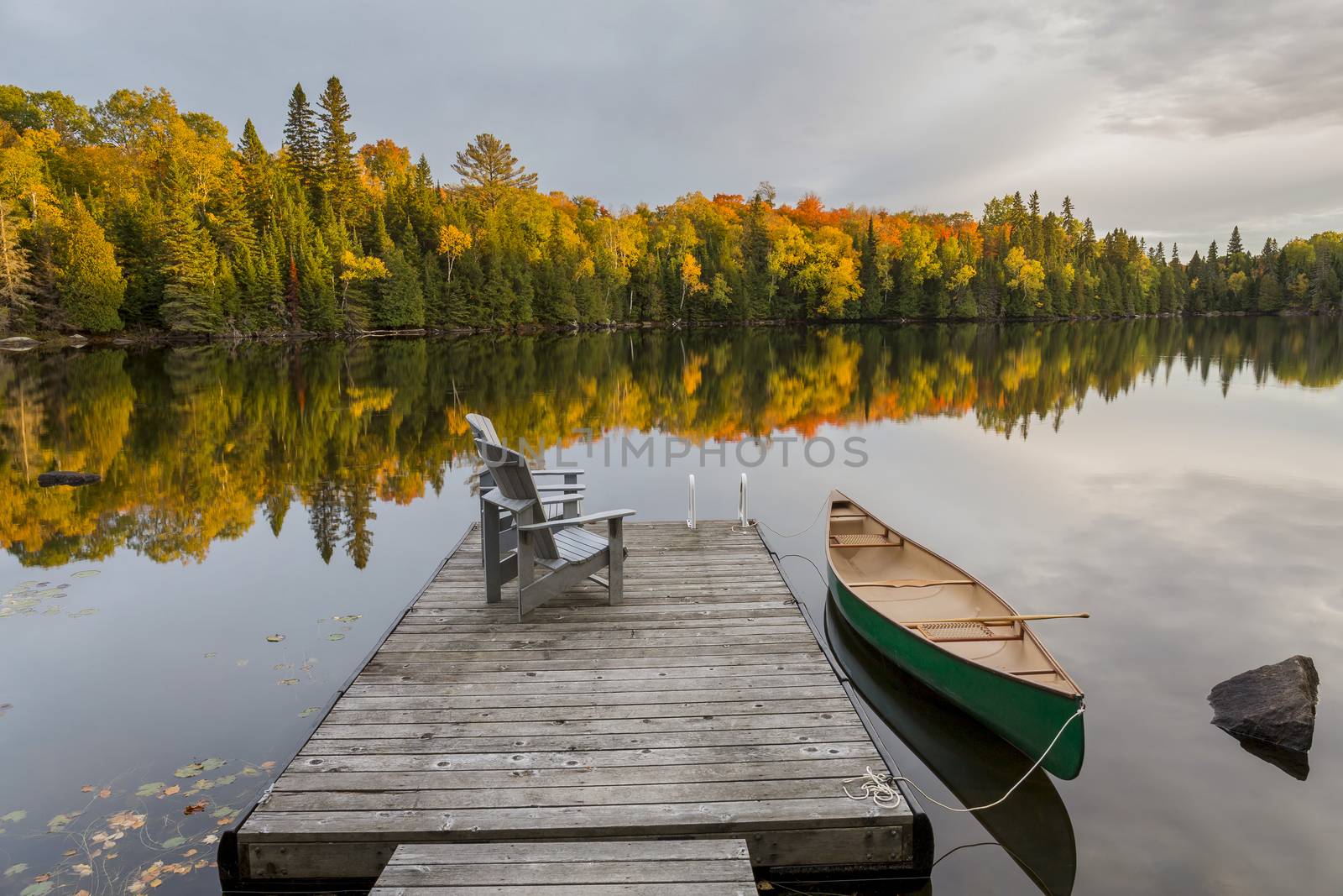 Canoe tied to a dock on an autumn lake in Ontario, Canada