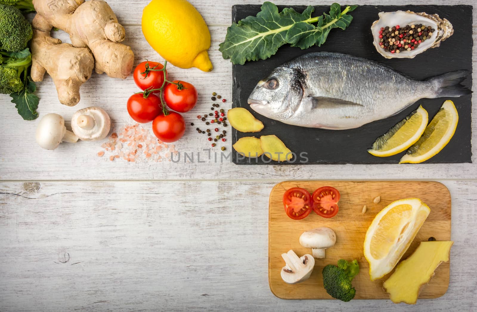  Fish, rich in protein, vitamins with vegetables, lemon and ginger, prepared for cooking on a white wooden table. Top view