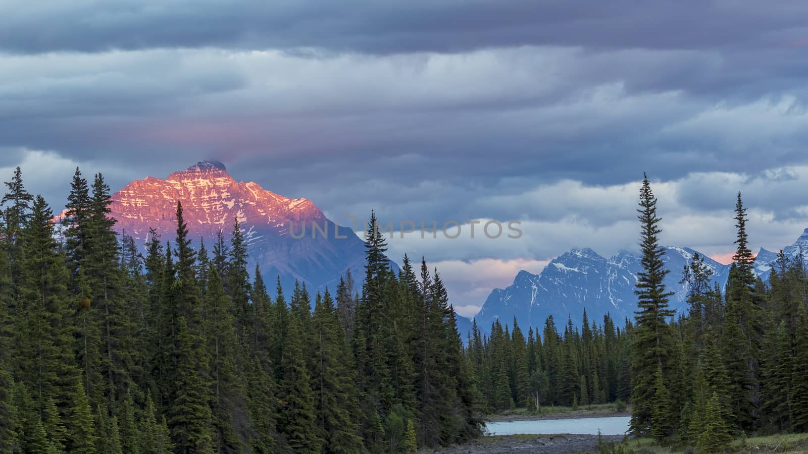 Athabasca River at Sunset with Rocky Mountains in Background by gonepaddling