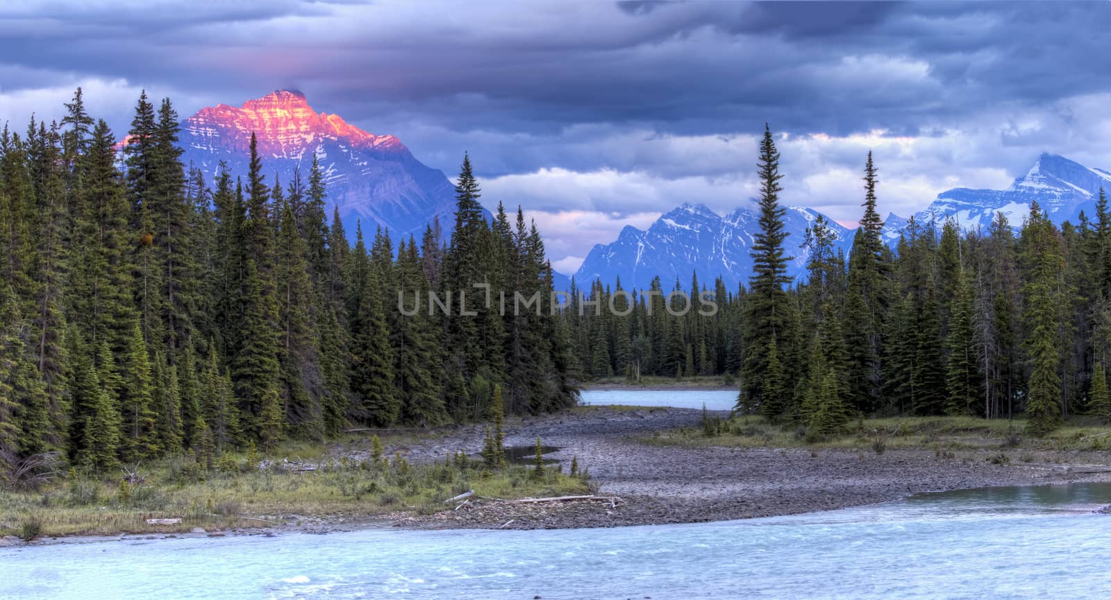 Athabasca River at Sunset with Rocky Mountains in Background by gonepaddling