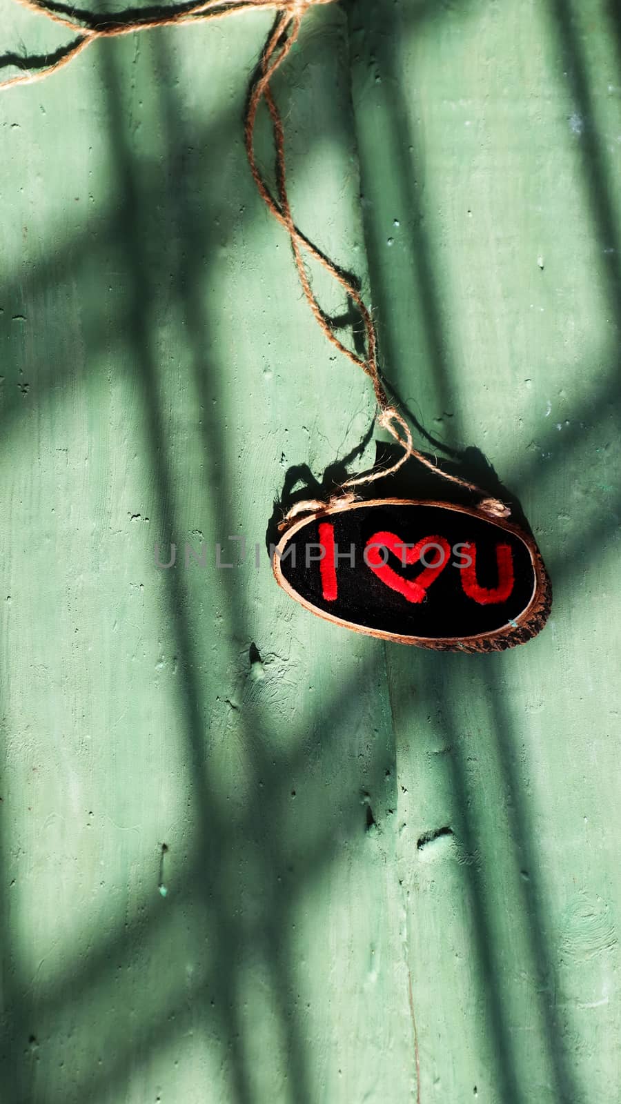 I love you letter in red color on black banner and green wood background, a romantic message for couple in february holiday, shades of sunlight on wood make impression