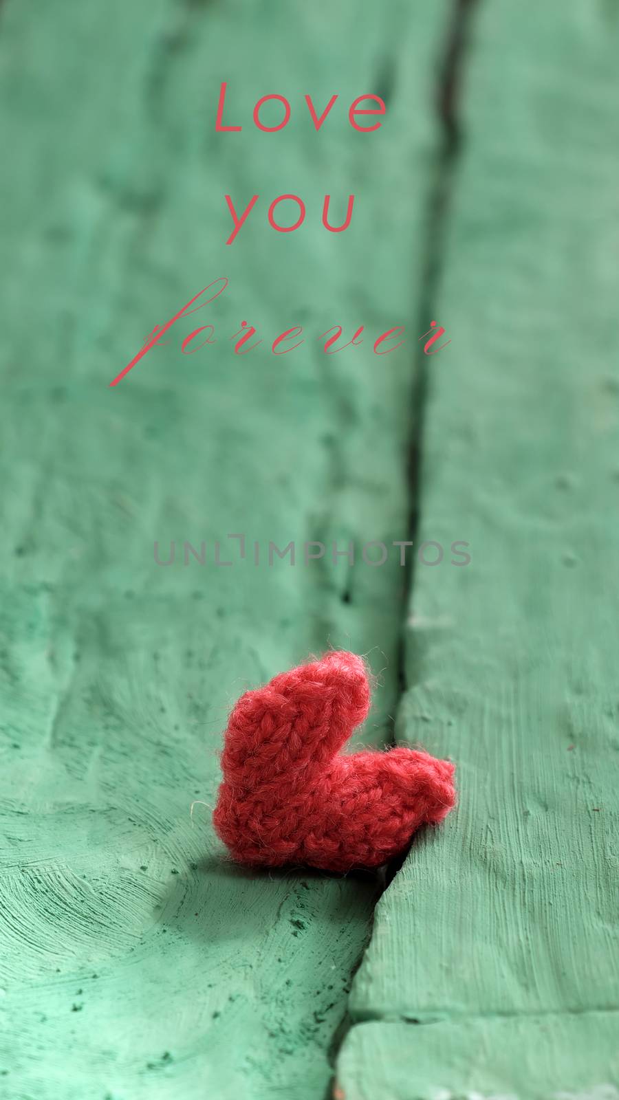 Abstract valentine background with red heart on green wooden in vintage color, knitted heart is symbol for romantic love of couple in feb 14