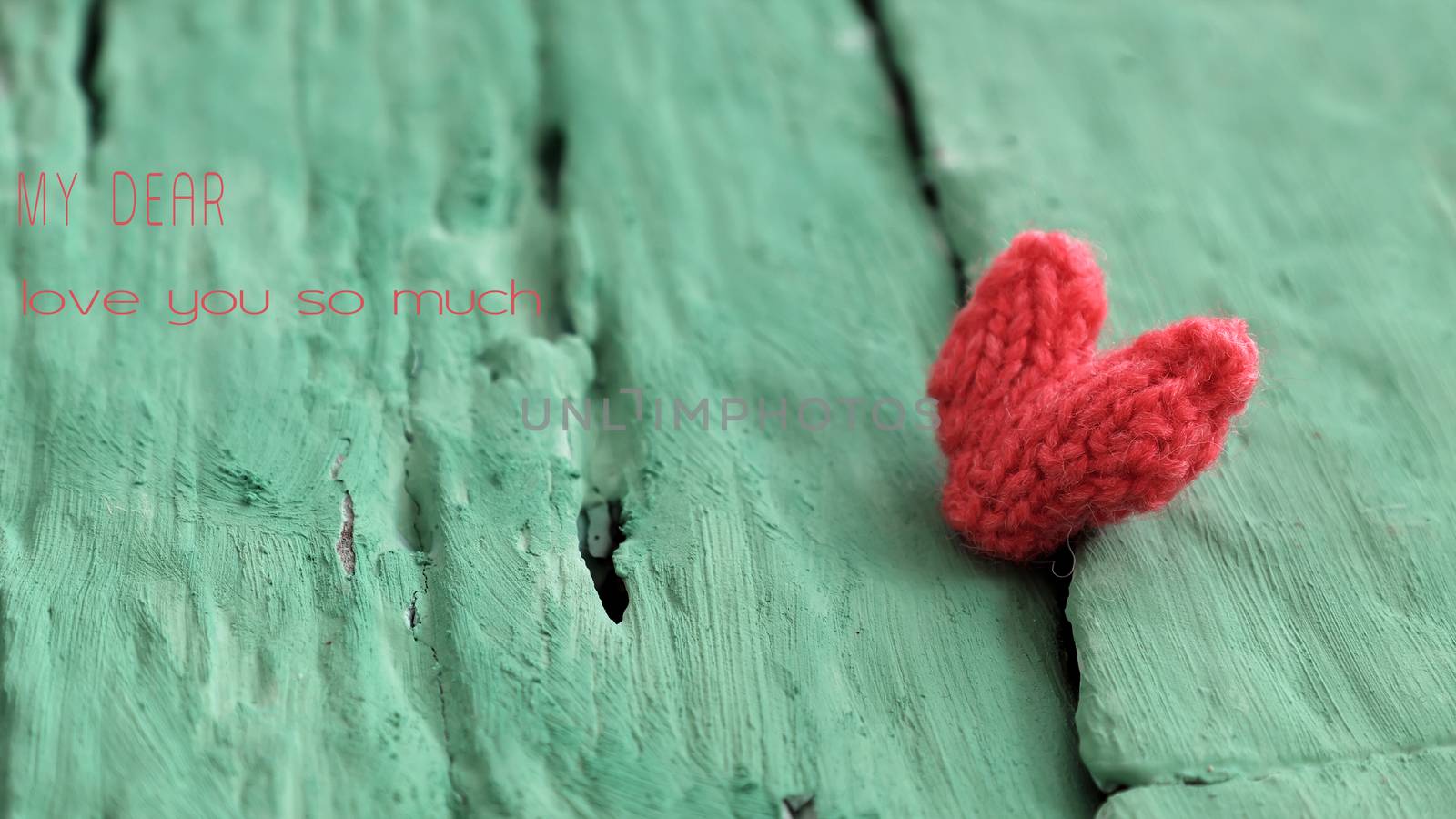 Abstract valentine background with red heart on green wooden in vintage color, knitted heart is symbol for romantic love of couple in feb 14