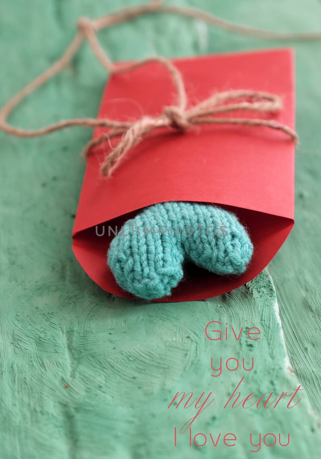 valentine green heart in red envelope on green wooden with vintage color, knitted heart is symbol for romantic love of couple in feb 14