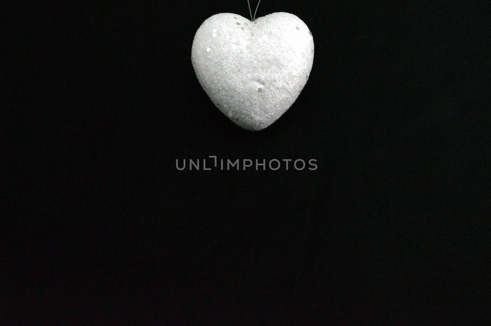 A white heart on a black background placed at the top in the middle