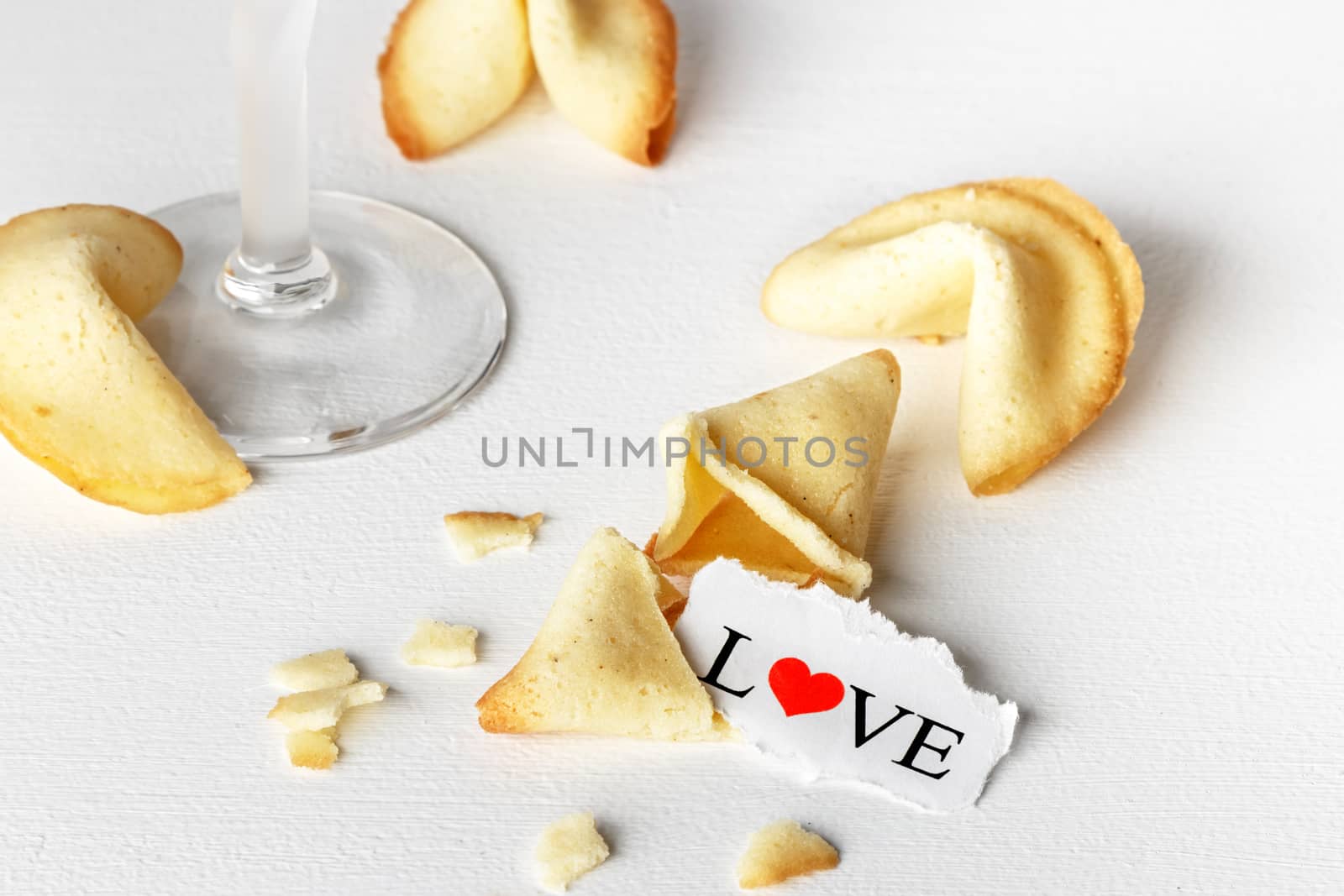 Cookies shaped like tortellini with the word love written on a paper and a glass of champagne.Horizontal image.