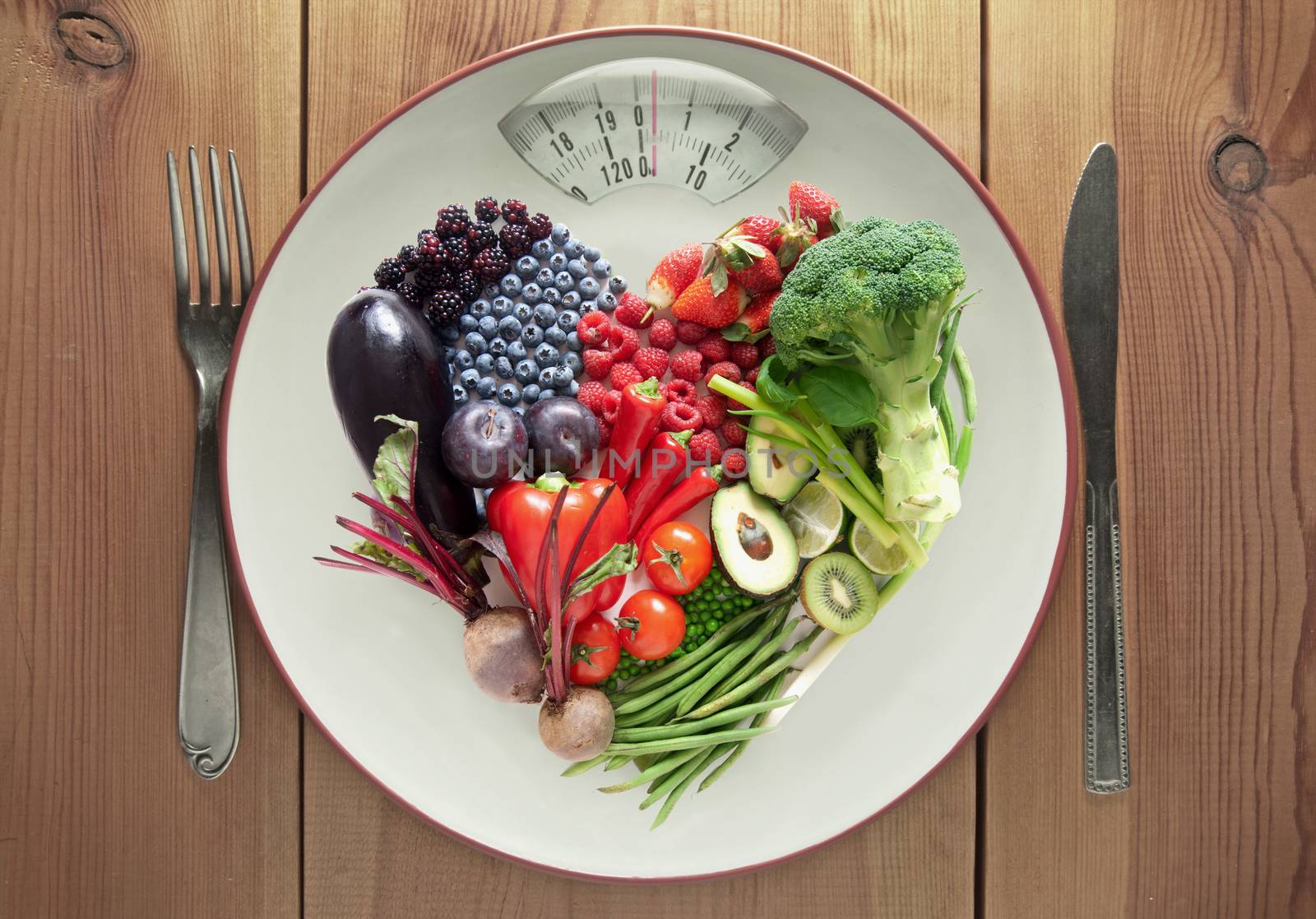 Plate with weighing scales packed with fruits and vegtables in a heart shape