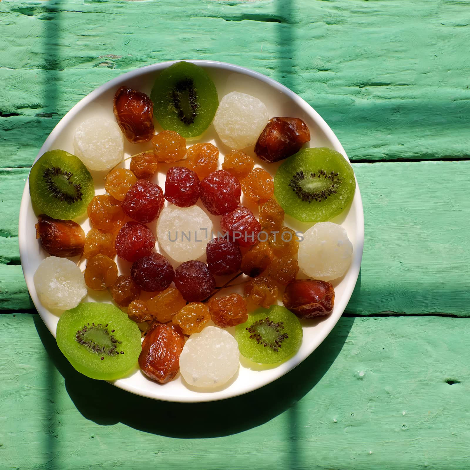 Group of colorful Vietnamese jam for Vietnam Tet holiday on green background, also lunar new year of Asia, traditional preserved fruit from kiwi, damson or coconut jam