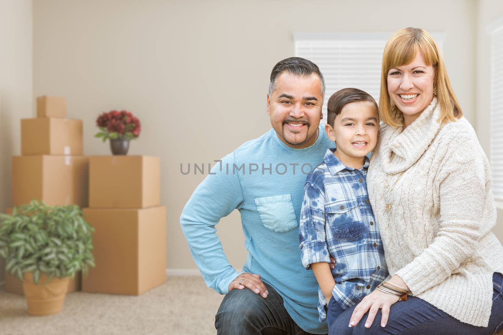 Mixed Race Family with Son in Room with Packed Moving Boxes by Feverpitched
