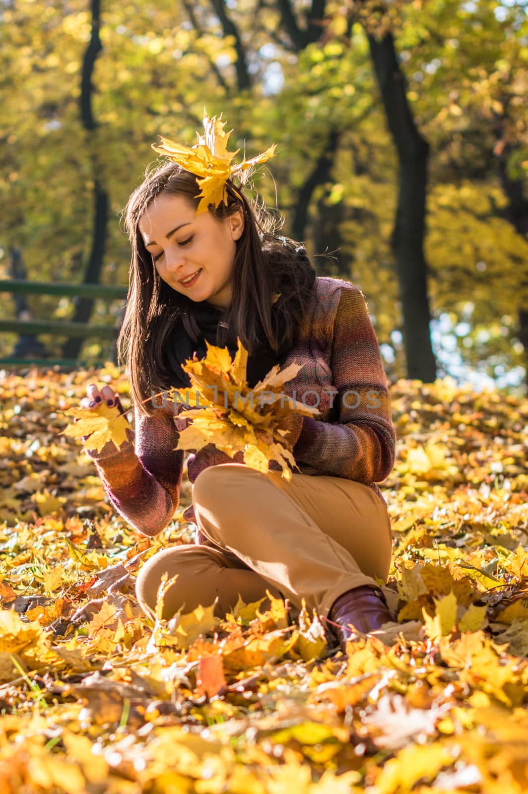 beautiful girl in autumn Park keeps yellow leaves