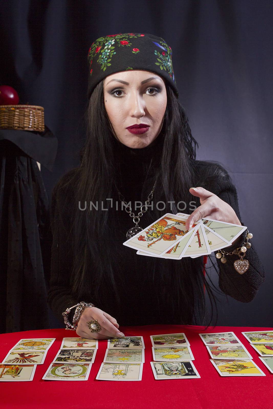 Gypsy woman wonders on the Tarot cards on a black background