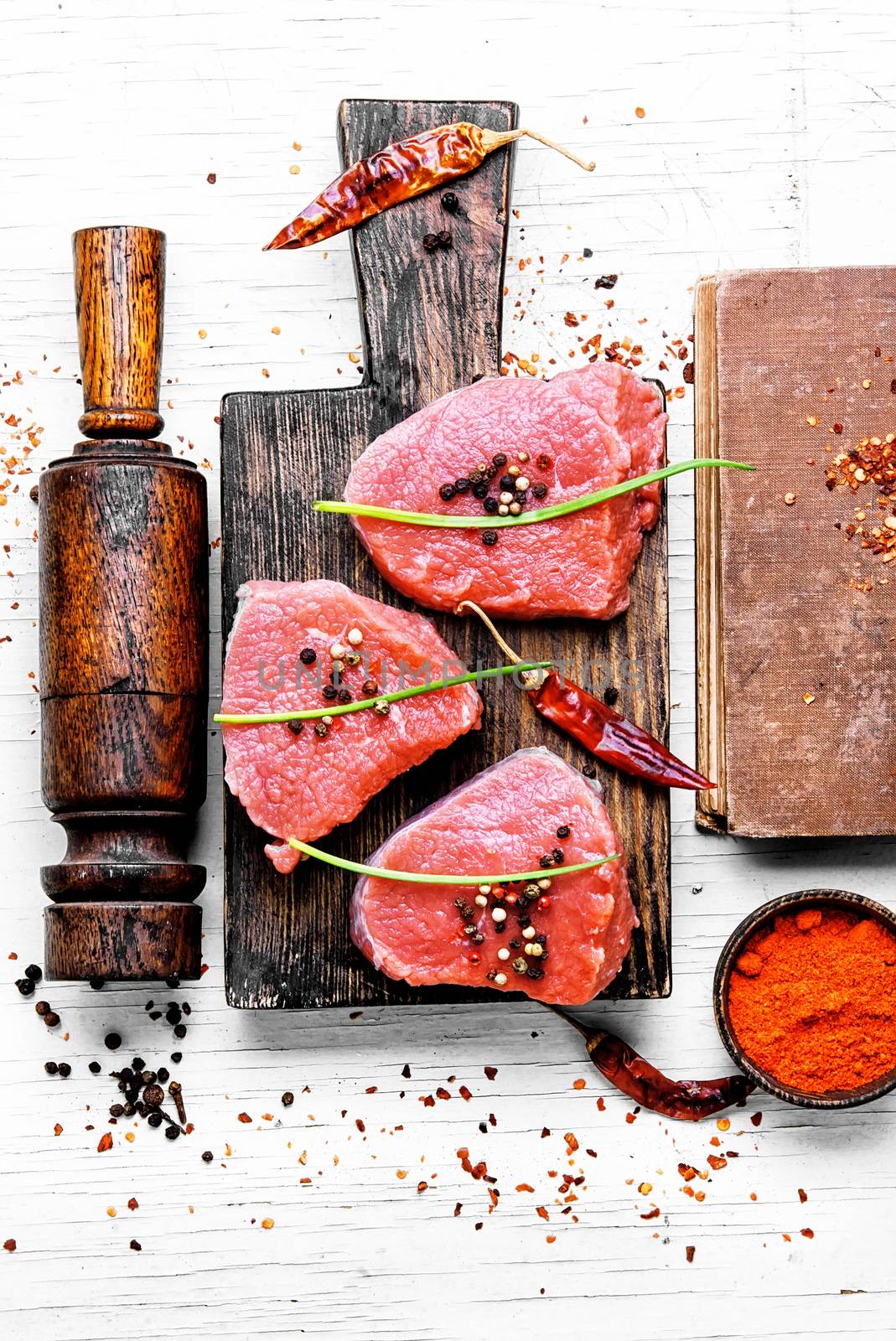 Three raw chops veal steak with peppers and spices