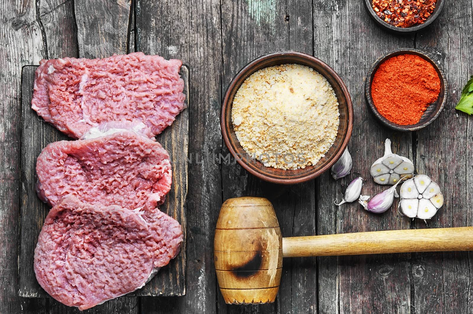 Raw veal chop steak on kitchen Board with spices