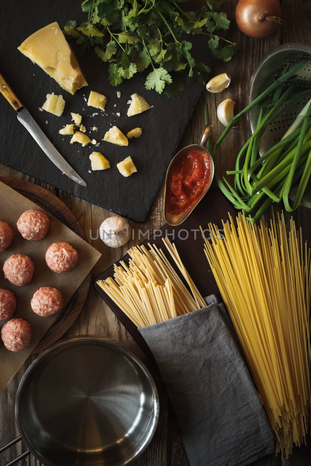 Ingredients for cooking spaghetti, meatballs with cheese and fresh herbs vertical top view