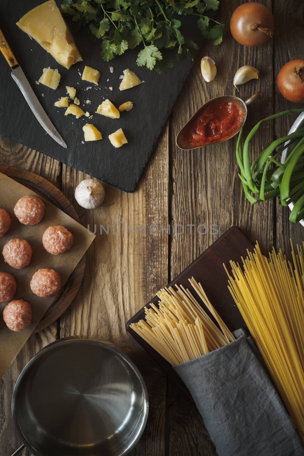 Ingredients for cooking spaghetti, meatballs with cheese and fresh herbs vertical copy space